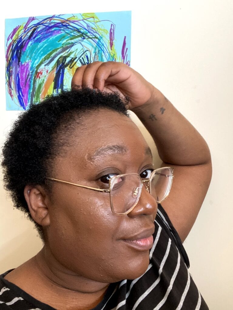 Tinuke facing to the side and grinning with freshly cut afro hair